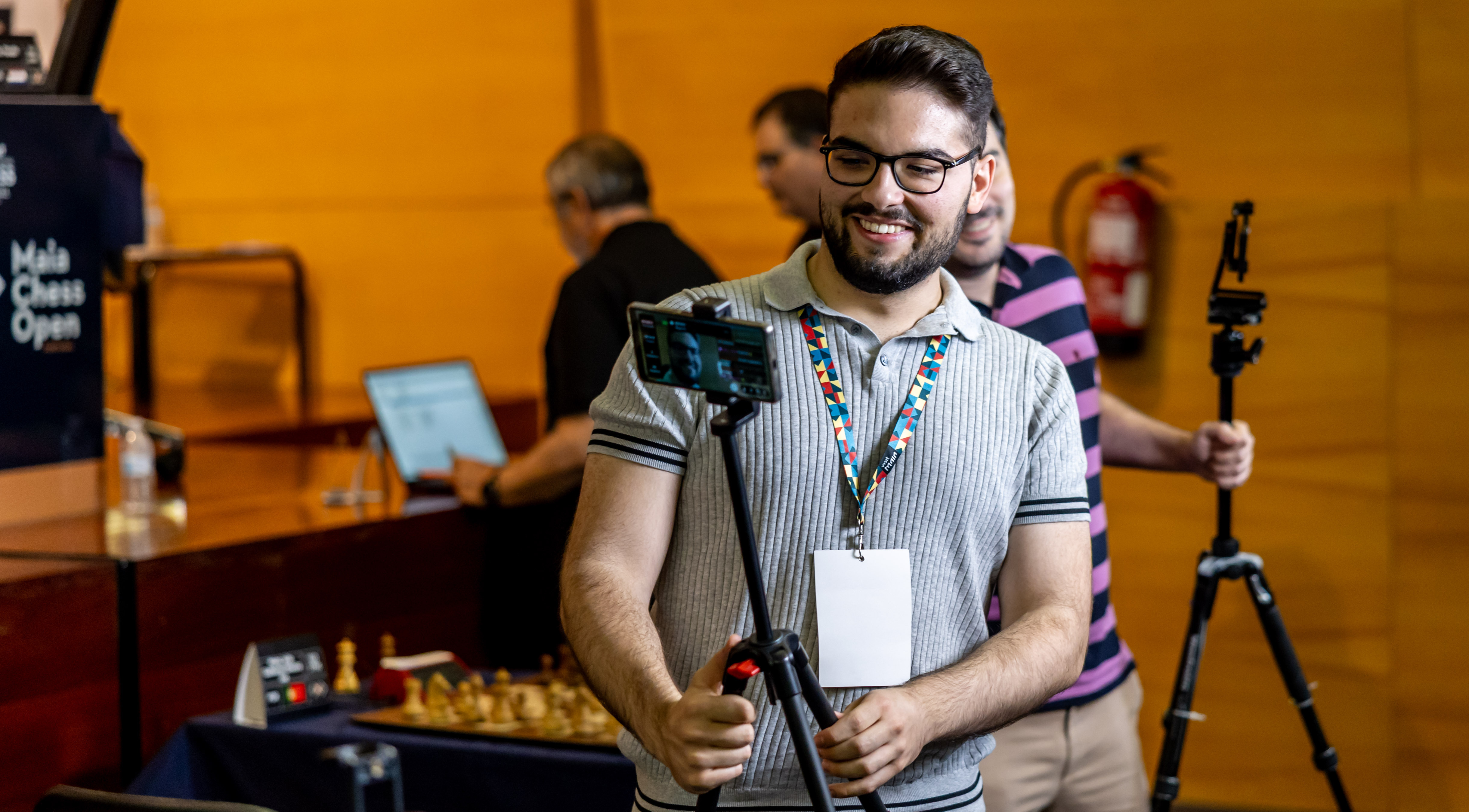 João Guilherme Matos filming a chess event with a camera on a tripod